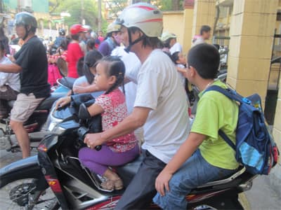Nhiều trẻ em chưa đội mũ bảo hiểm khi ngồi trên xe gắn máy