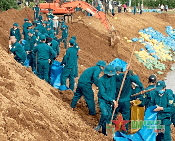 Bộ đội, dân quân giúp dân gia cố sạt lở bờ sông