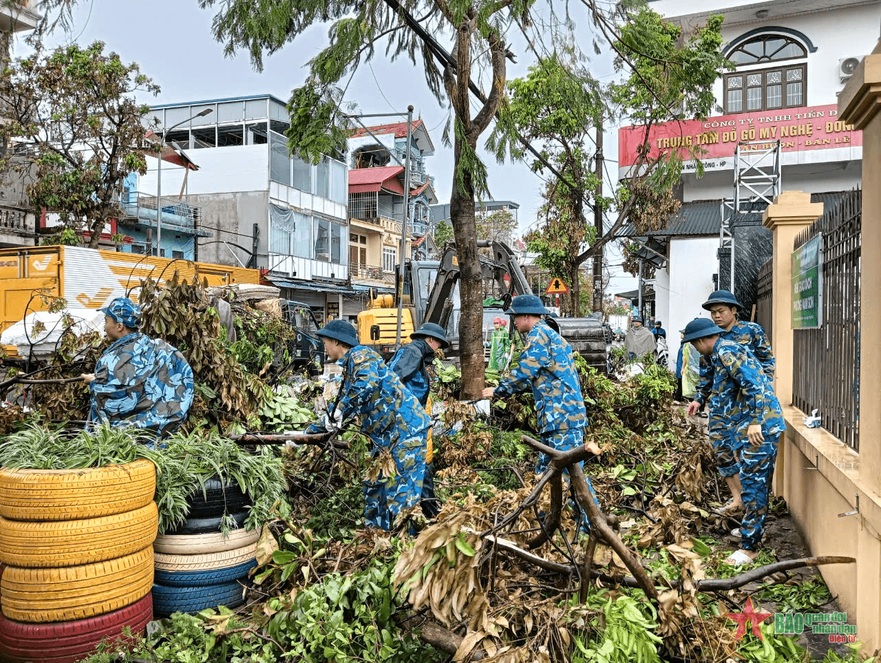 Sư đoàn 363 giúp nhân dân thu gom rác thải, cành cây gãy đổ lưu thông tuyến đường