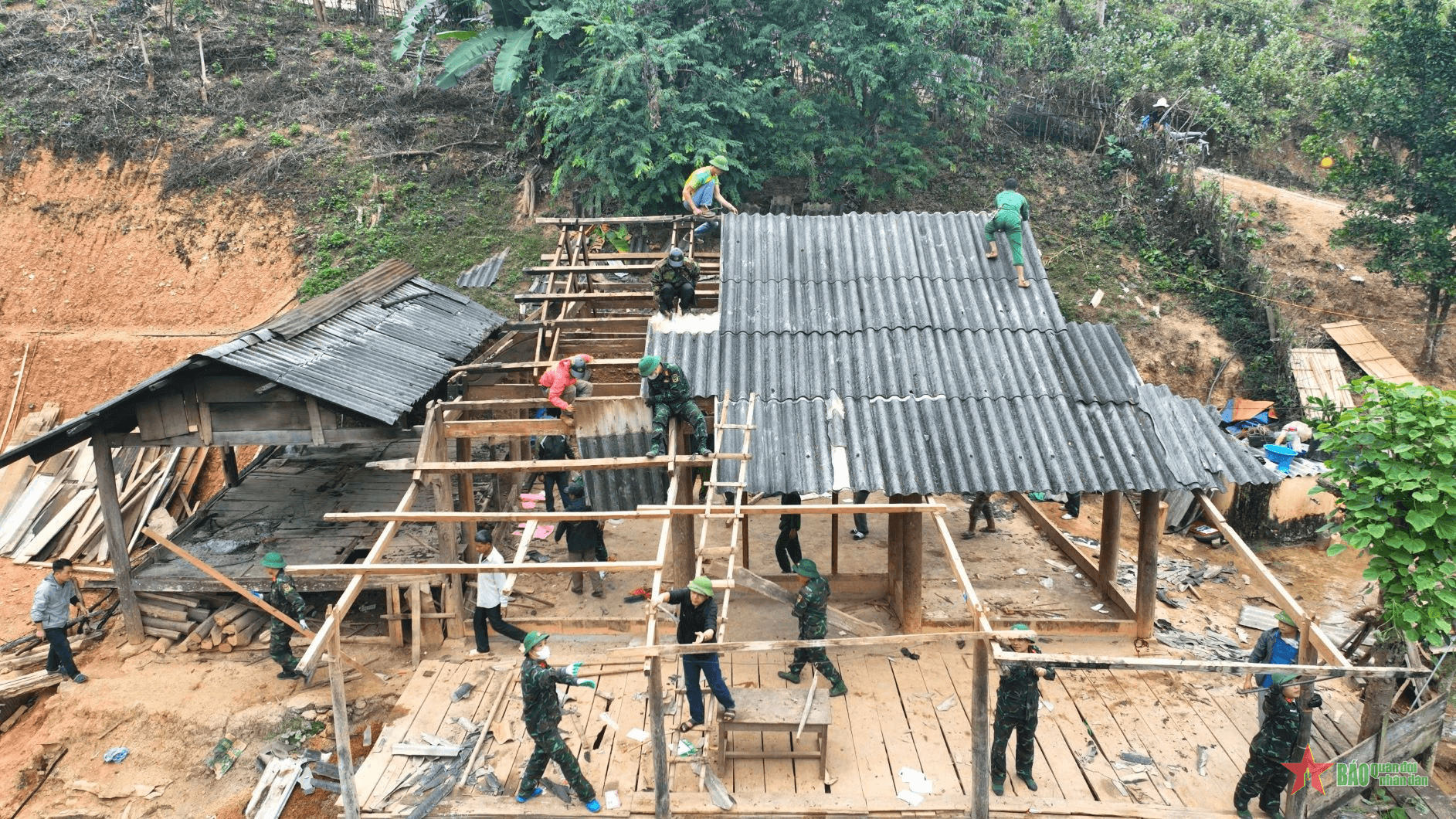Cán bộ, chiến sĩ huyện Kỳ Sơn (Nghệ An) hỗ trợ dân di dời nhà cửa đến khu tái định cư